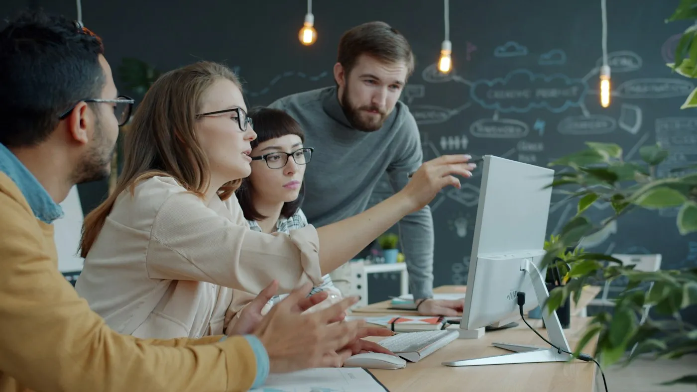 A team reviewing work together on a desktop screen